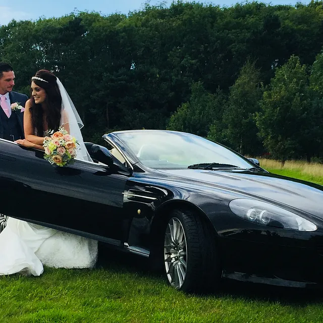 aston marton with bride and groom